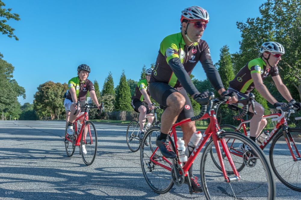 Group of people riding a bike during Sales Factory's bike to work week